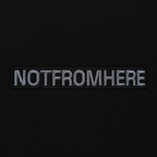 Close-up NOTFROMHERE logo detail on black oversized t-shirt