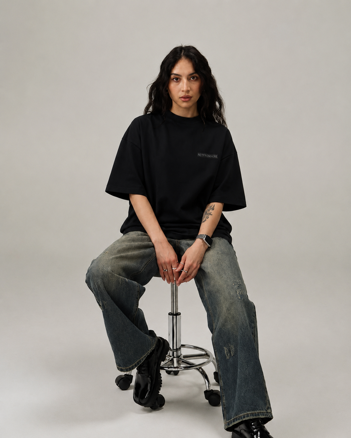 Oversized fit of ARTEFACT Série 01 black heavyweight t-shirt worn seated